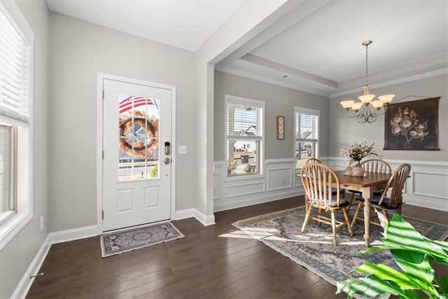 dining room with a tray ceiling, dark wood-type flooring, and a chandelier