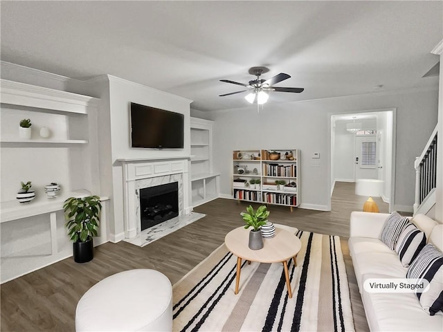 living room featuring ornamental molding, hardwood / wood-style floors, ceiling fan, and a premium fireplace