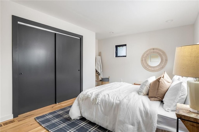 bedroom with wood-type flooring and a closet