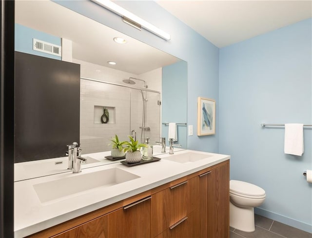 bathroom featuring vanity, tile patterned flooring, a shower with door, and toilet