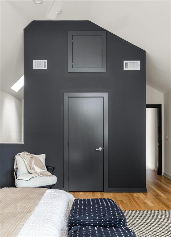 bedroom with lofted ceiling and hardwood / wood-style flooring