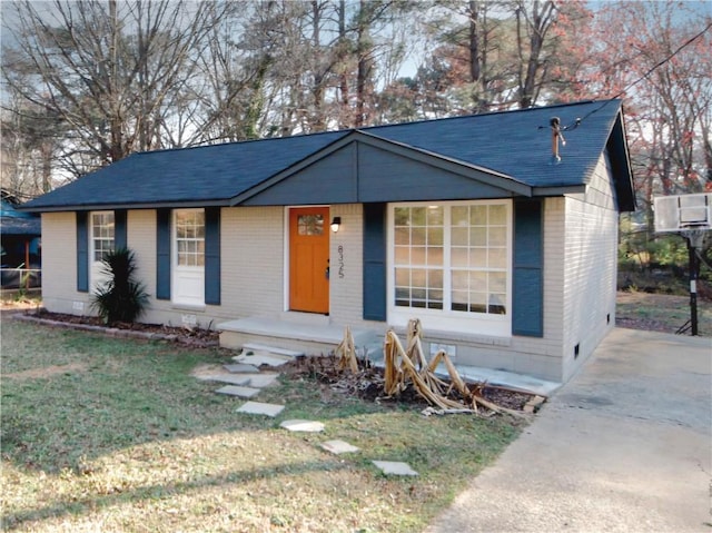 view of front facade featuring a front yard, brick siding, roof with shingles, and crawl space