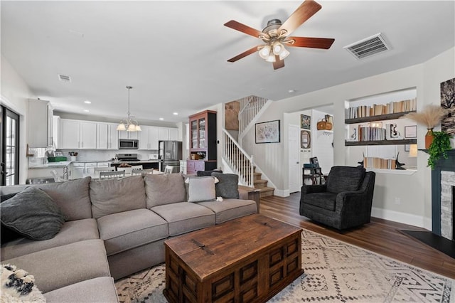 living room with ceiling fan, light wood-style flooring, stairway, baseboards, and recessed lighting