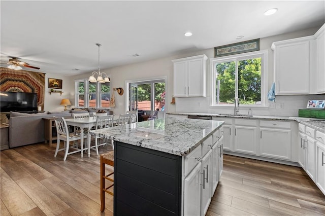 kitchen with a sink, ceiling fan, open floor plan, decorative backsplash, and recessed lighting