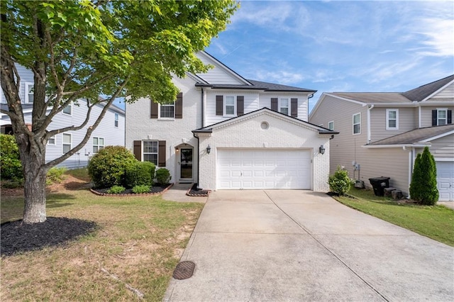 traditional home featuring an attached garage, concrete driveway, a front lawn, and brick siding