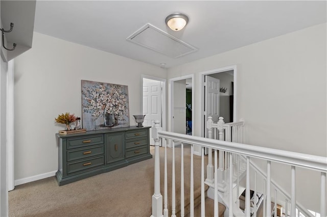 hallway with attic access and carpet flooring
