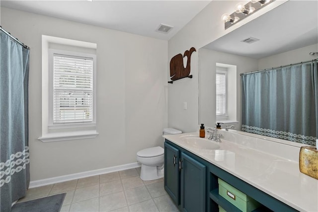 bathroom featuring healthy amount of natural light, baseboards, vanity, and toilet