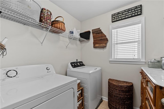 washroom with washer and dryer, baseboards, and light tile patterned floors