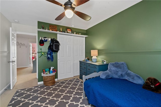 bedroom featuring a closet, baseboards, ceiling fan, and carpet