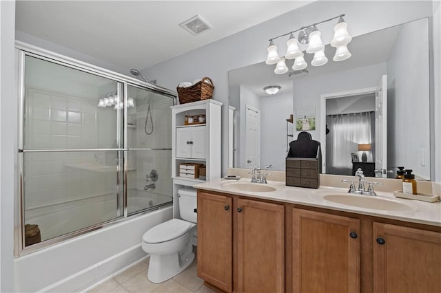 bathroom featuring a chandelier, double vanity, tile patterned flooring, toilet, and combined bath / shower with glass door