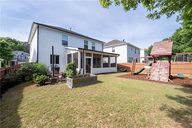 rear view of property with a sunroom and a playground