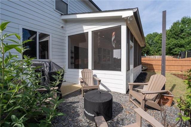 view of side of property featuring a sunroom and fence