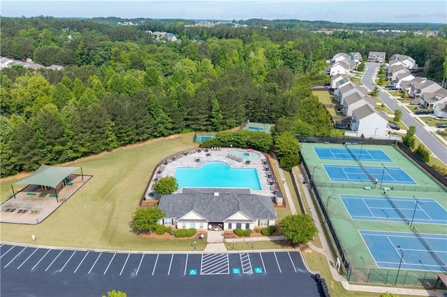 bird's eye view of a heavily wooded area and a pool