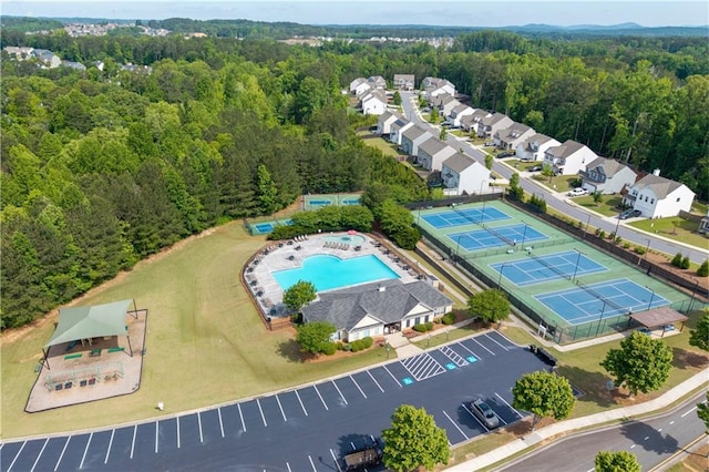 bird's eye view of a heavily wooded area and a pool area