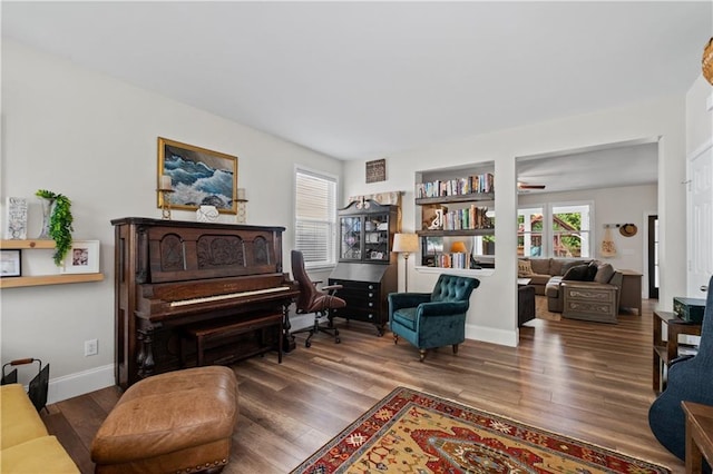 sitting room featuring wood finished floors, ceiling fan, and baseboards