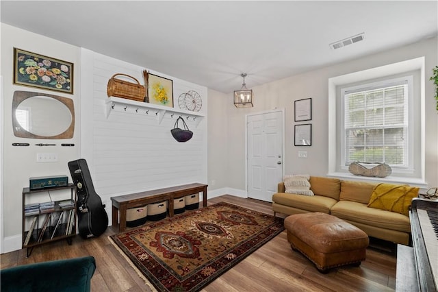 living room with wood finished floors, a chandelier, and baseboards
