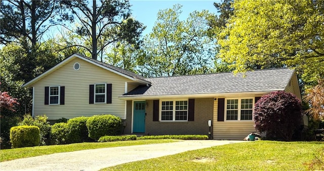 split level home with a front lawn and roof with shingles