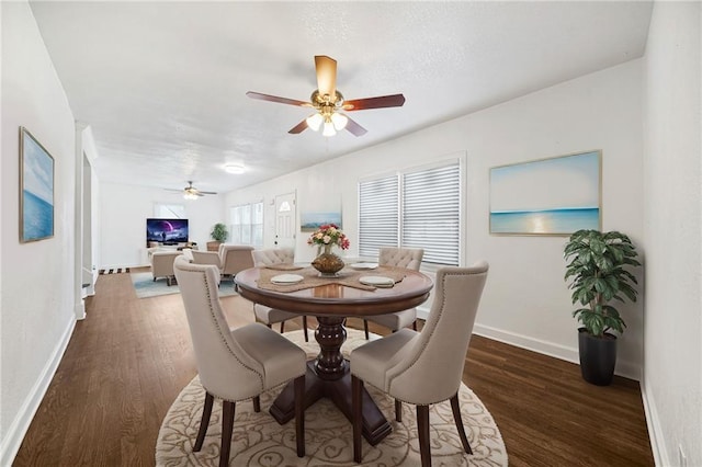 dining area with dark wood-type flooring and ceiling fan