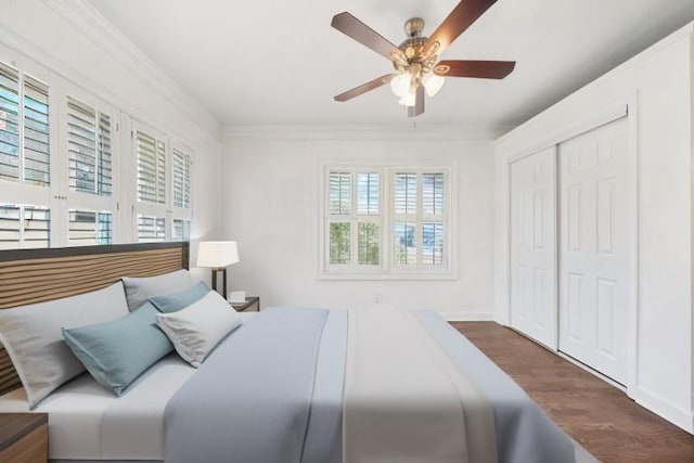 bedroom with a closet, crown molding, dark hardwood / wood-style floors, and ceiling fan