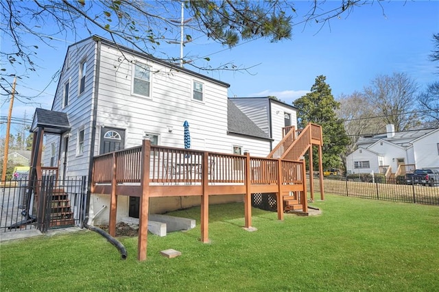 rear view of house featuring a wooden deck and a yard