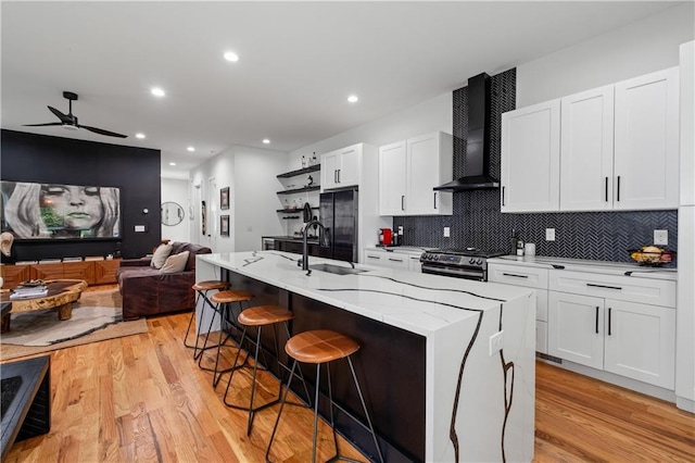 210 Locust St NE, Atlanta, GA 30317 - kitchen featuring freestanding refrigerator, wall chimney exhaust hood, a ceiling fan, light wood finished floors, and gas stove
