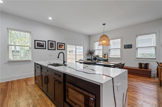210 Locust St NE, Atlanta, GA 30317 - kitchen featuring a kitchen island with sink, dishwasher, a sink, stainless steel microwave, and light wood-style flooring