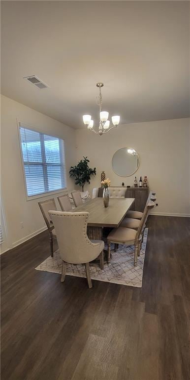 dining room featuring dark wood-type flooring and a chandelier