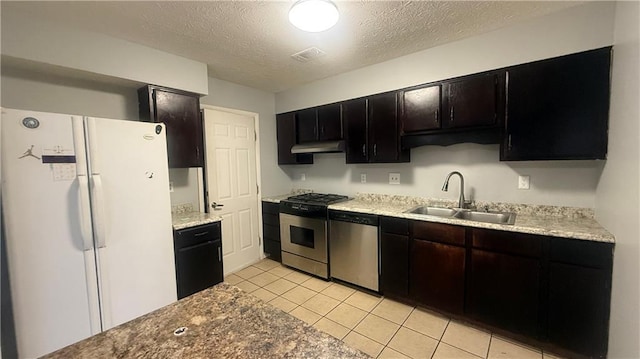 kitchen with light tile patterned flooring, appliances with stainless steel finishes, a textured ceiling, and sink