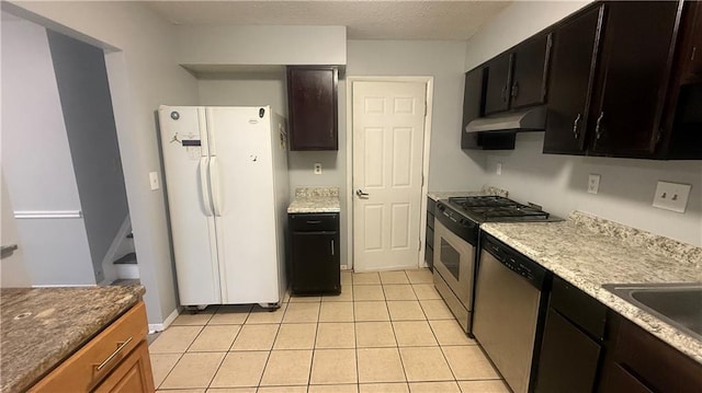 kitchen with light tile patterned floors, a textured ceiling, and stainless steel appliances