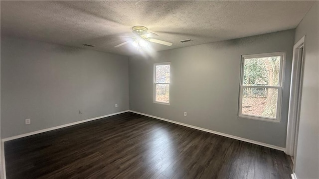 empty room with a textured ceiling, ceiling fan, and dark hardwood / wood-style floors