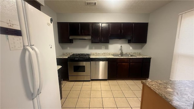 kitchen with dark brown cabinets, a textured ceiling, stainless steel appliances, sink, and light tile patterned flooring