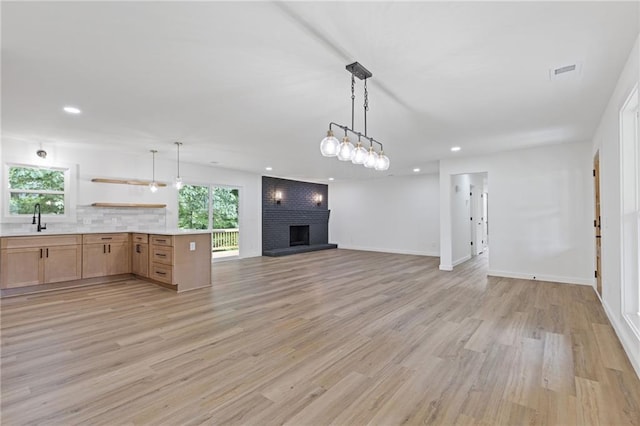 6142 Hutchins Dr, Buford, GA 30518 - kitchen with open floor plan, light countertops, a brick fireplace, recessed lighting, and healthy amount of natural light