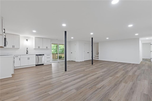 6142 Hutchins Dr, Buford, GA 30518 - unfurnished living room featuring light wood-style floors, recessed lighting, a sink, stairs, and baseboards