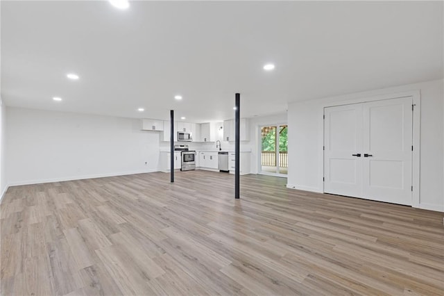 6142 Hutchins Dr, Buford, GA 30518 - basement with light wood-style flooring, recessed lighting, baseboards, and a sink