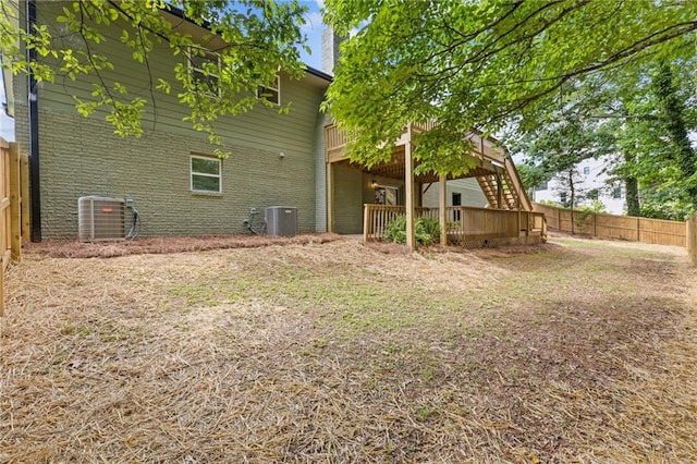 6142 Hutchins Dr, Buford, GA 30518 - back of house featuring central air condition unit, brick siding, a wooden deck, a fenced backyard, and a chimney