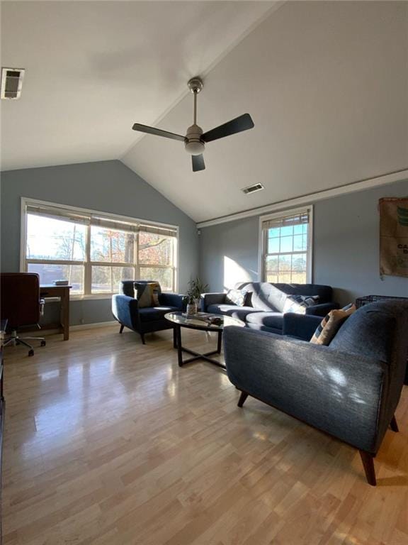 living area featuring light wood-type flooring, visible vents, and lofted ceiling