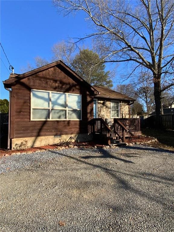 view of front of property with crawl space and fence