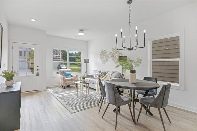 dining area with an inviting chandelier and light hardwood / wood-style flooring