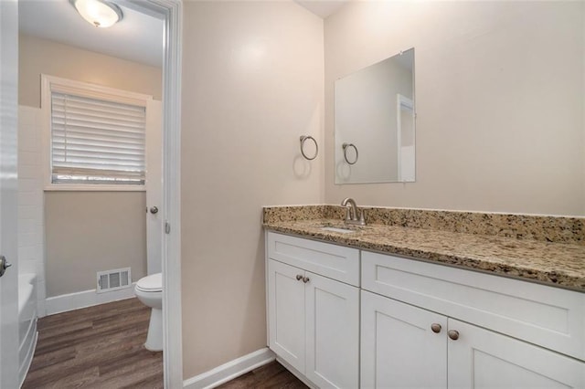 bathroom with hardwood / wood-style flooring, vanity, and toilet