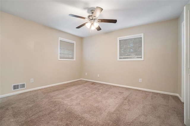 carpeted spare room featuring ceiling fan