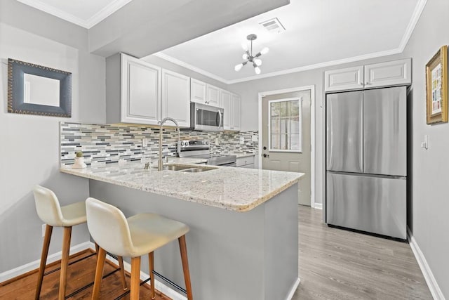 kitchen featuring white cabinetry, stainless steel appliances, a breakfast bar, and sink