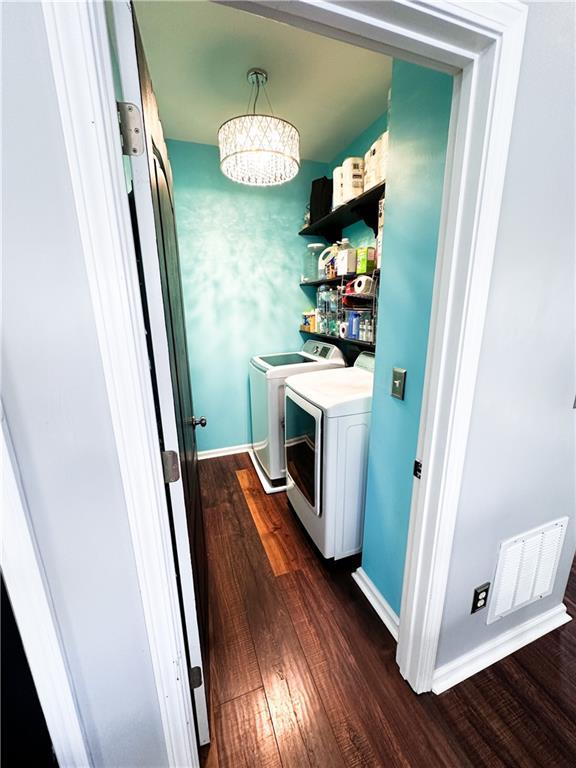laundry room featuring dark wood-style flooring, washer and dryer, and baseboards