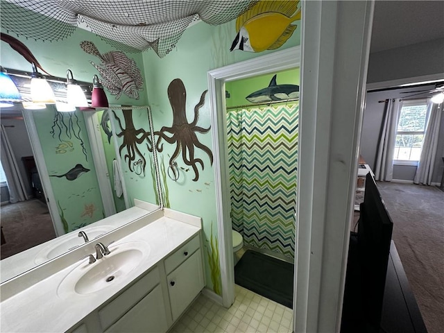 bathroom with toilet, vanity, and a shower with curtain