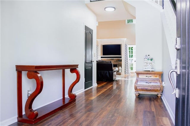 entrance foyer with wood finished floors, baseboards, and a towering ceiling