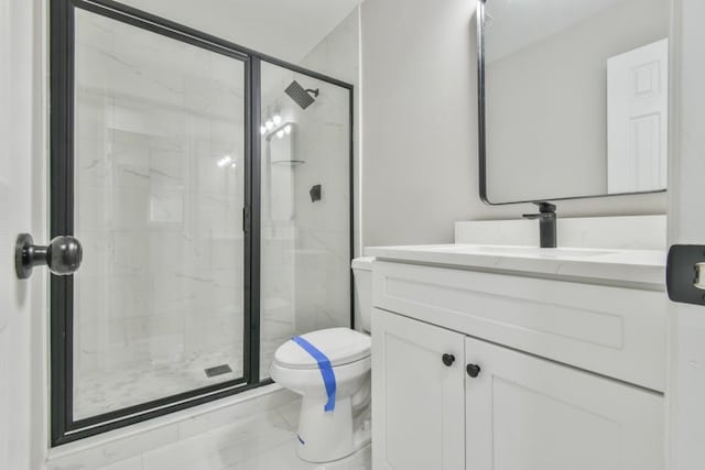 bathroom with toilet, vanity, and a shower with shower door