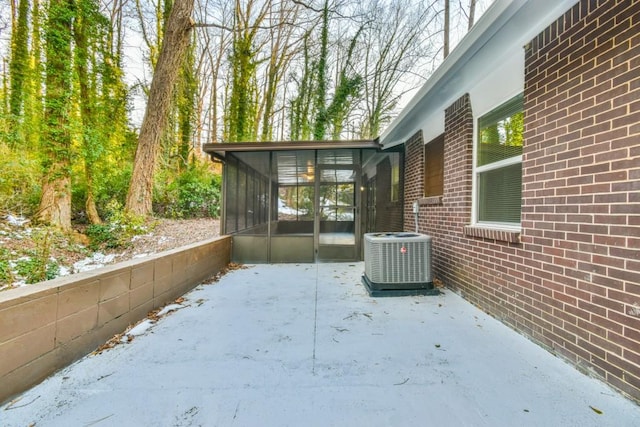 view of side of property featuring a patio area, central air condition unit, and a sunroom