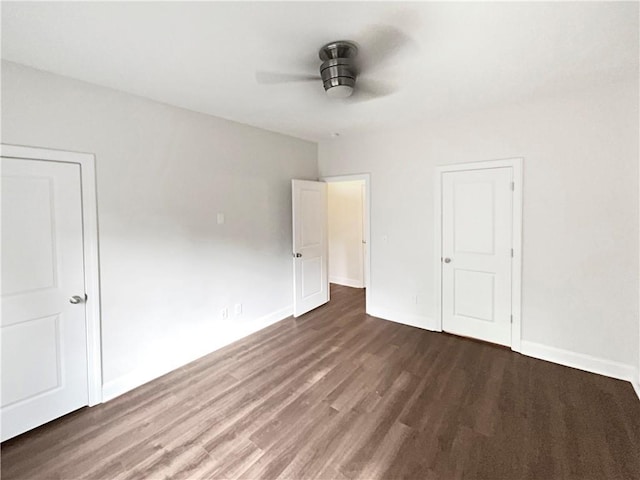 unfurnished bedroom featuring dark wood-style floors, a ceiling fan, and baseboards