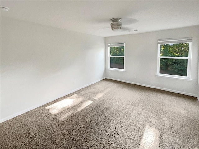 spare room featuring carpet floors and baseboards