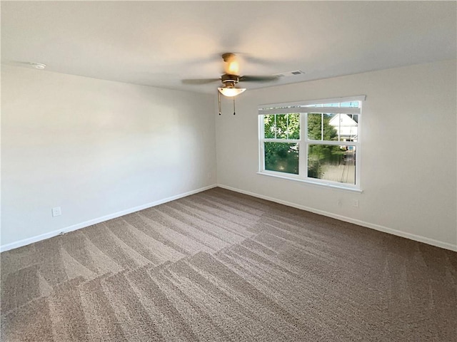 unfurnished room featuring a ceiling fan, carpet, visible vents, and baseboards