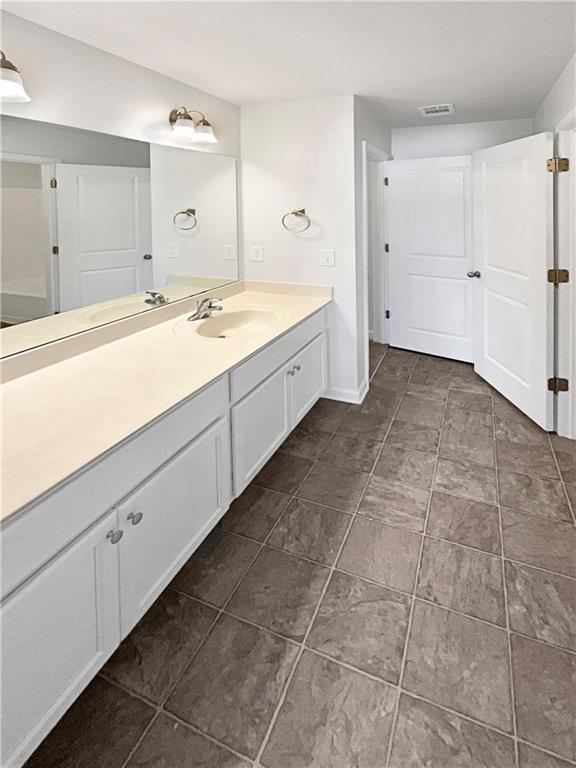 bathroom with baseboards, visible vents, and vanity